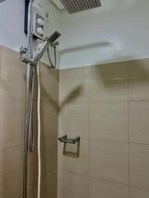 a shower in a bathroom with a shower head at Airport-side Shore Staycation in Manila