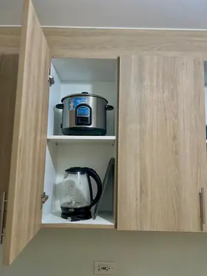 a cabinet with a pot and a blender in it at Airport-side Shore Staycation in Manila