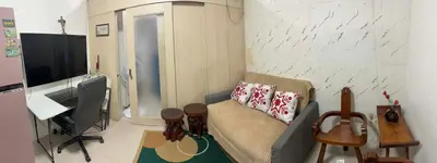 a living room with a couch and a television at Light Residences by SMDC Boni MRT EDSA in Manila
