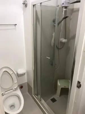a bathroom with a toilet and a glass shower at Light Residences by SMDC Boni MRT EDSA in Manila