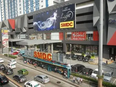 a busy city street with cars parked in front of a building at Light Residences by SMDC Boni MRT EDSA in Manila