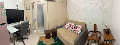a living room with a couch and a television at Light Residences by SMDC Boni MRT EDSA in Manila