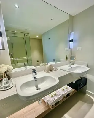 a bathroom with two sinks and a large mirror at Hotel Residences at Acqua in Manila