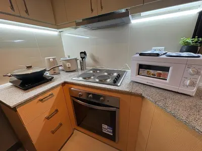 a kitchen with a stove and a microwave at Luxury-Styled 2BR Uptown T2 Parksuites BGC in Manila