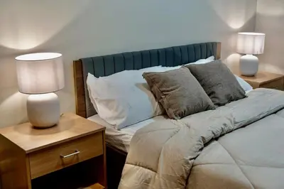 a bedroom with a bed with pillows and two lamps at Luxury-Styled 2BR Uptown T2 Parksuites BGC in Manila