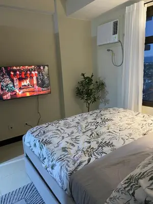 a bedroom with a bed and a painting on the wall at Sofi Staycation- Aurora Escalades in Manila