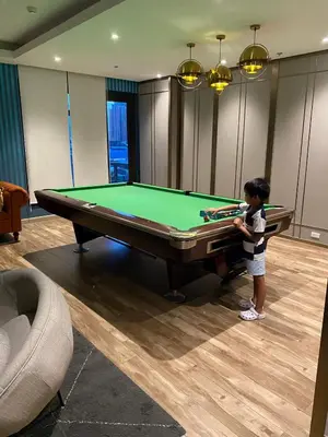 a young child standing next to a pool table at Sofi Staycation- Aurora Escalades in Manila