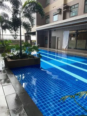 a blue swimming pool in front of a building at Sofi Staycation- Aurora Escalades in Manila