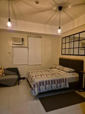 a bedroom with a bed and a couch and lights at Jacob's Place Near Manila Airport in Manila