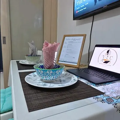 a table with two plates and a laptop on it at MOA Staycation - Sea Residences - Tower C in Manila