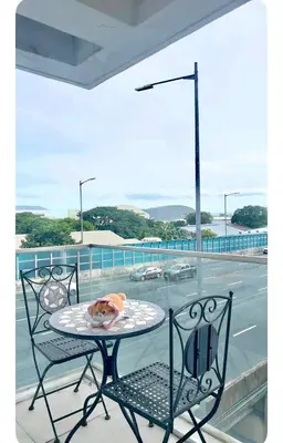 a table and two chairs on a balcony at NAIA Terminal 3 Kaydren Airport Suite I Walk to Casino & Mall l 9-mins to Naia l Modern Stay 1 Bedroom in Manila