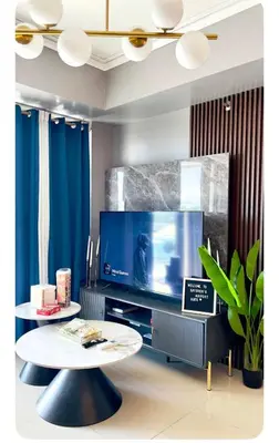a living room with a tv and a coffee table at NAIA Terminal 3 Kaydren Airport Suite I Walk to Casino & Mall l 9-mins to Naia l Modern Stay 1 Bedroom in Manila