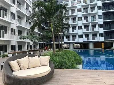 a wicker chair sitting in front of a building at Shore Residences Condo MOA NAIA with Netflix WiFi Access in Manila