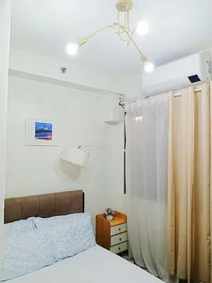 a bedroom with a bed and a light at Shore Residences Condo MOA NAIA with Netflix WiFi Access in Manila