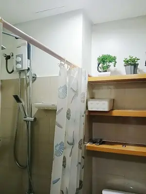 a bathroom with a shower with a shower curtain at Shore Residences Condo MOA NAIA with Netflix WiFi Access in Manila