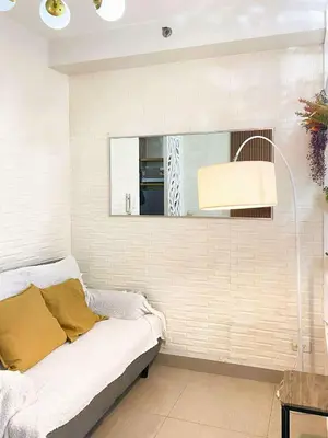 a living room with a bed and a mirror at Shore Residences Condo MOA NAIA with Netflix WiFi Access in Manila