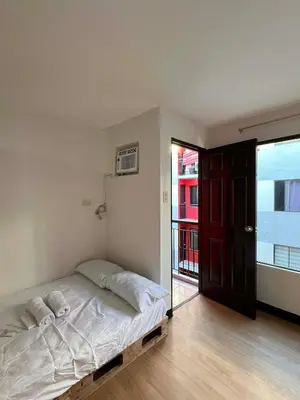 a bedroom with a bed and a large window at Jade Condo Netflix Wifi Karaoke with Cinema Projector in Imus