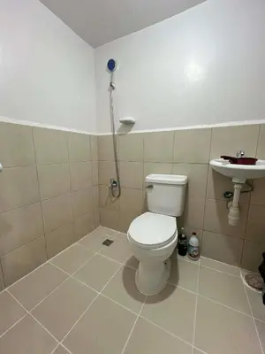 a bathroom with a toilet and a sink at Jade Condo Netflix Wifi Karaoke with Cinema Projector in Imus