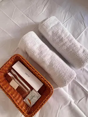two towels in a wicker basket on a bed at Jade Condo Netflix Wifi Karaoke with Cinema Projector in Imus
