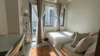 a bedroom with a bed and a large window at Kabina Suites at Fame Residences in Manila