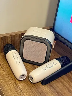 two remote controls and a speaker next to a computer at Kabina Suites at Fame Residences in Manila