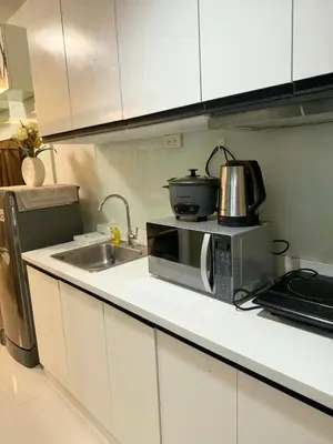 a kitchen counter with a microwave and a sink at RoseCondoHotel in Manila