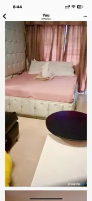 a bedroom with a bed with a table and a plate on it at RoseCondoHotel in Manila