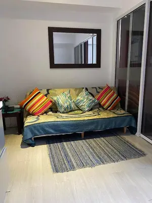 a couch in a living room with a mirror at AFFORDABLE STAYCATION NEAR Airport in Manila