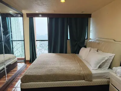 a bedroom with a bed and a large window at mooring in Manila