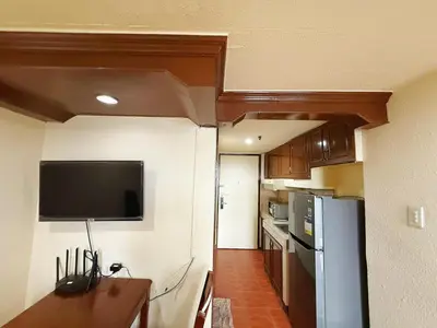 a kitchen with a refrigerator and a tv on the wall at mooring in Manila