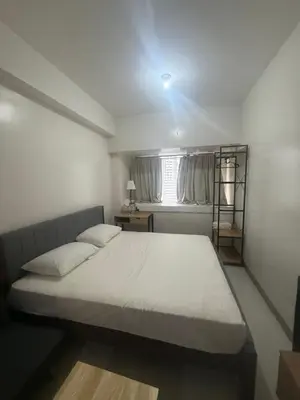a bedroom with a bed and a window at The Vibe at SMDC The Lush Residences in Manila