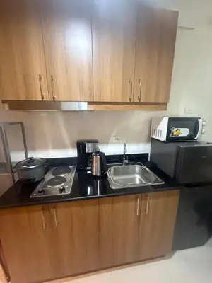 a small kitchen with a sink and a microwave at The Vibe at SMDC The Lush Residences in Manila