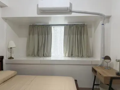 a bedroom with a bed and a window with curtains at The Fortress at SMDC The Lush Residences in Manila