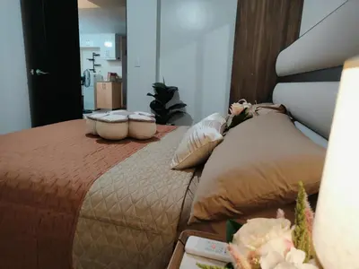 a bedroom with a bed with pillows on it at Jpad Suites in Manila
