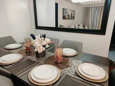 a dining room table with white plates on it at Jpad Suites in Manila