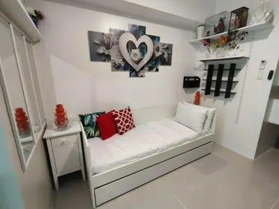 a white couch with pillows on it in a room at Lornas Staycation in Manila