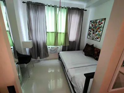 a small bedroom with a bed and a window at Lornas Staycation in Manila