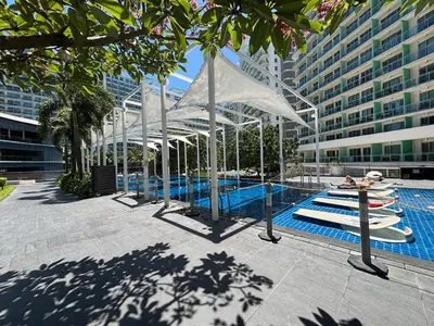 a swimming pool with a white structure next to a building at 1BR Condotel in Azure Urban Resort near NAIA #TRO4 in Manila