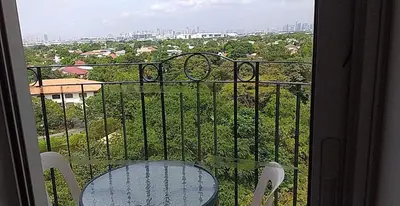 a table and chairs on a balcony with a view at CJ Chateau Elysse in Manila