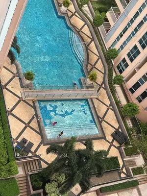 an overhead view of a large swimming pool with palm trees at Venice Luxury Residences Emanuele in Manila