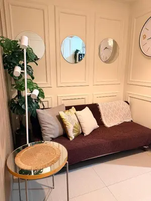 a living room with a couch and a table at Relaxing 1BR Condo near MOA & NAIA with WiFi, PS4, Karaoke in Manila