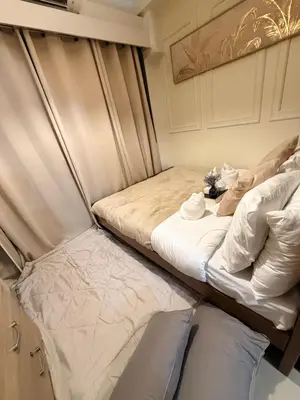 two beds sitting next to each other in a room at Relaxing 1BR Condo near MOA & NAIA with WiFi, PS4, Karaoke in Manila