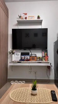 a living room with a table and a tv at Staycation near NAIA, MOA with PS4, Netflix & Karaoke in Manila