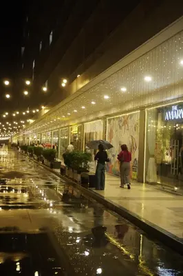 two people standing in front of a store in the rain at Staycation near NAIA, MOA with PS4, Netflix & Karaoke in Manila