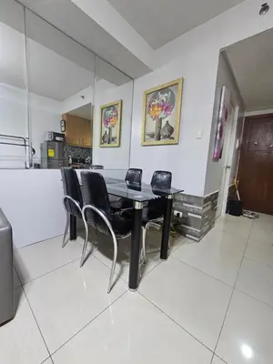 a dining room with a black table and chairs at Shore Residences Tower D Viann in Manila
