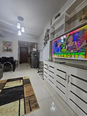 a living room with a large flat screen tv at Shore Residences Tower D Viann in Manila