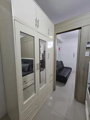 a living room with a television and a couch at Shore Residences Tower D Viann in Manila