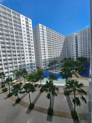 a large apartment complex with palm trees and buildings at Shore Residences Tower D Viann in Manila
