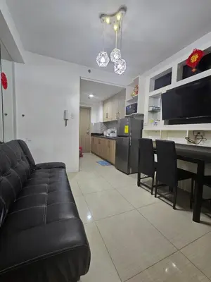 a living room with a black couch and a table at Shore Residences Tower D Viann in Manila