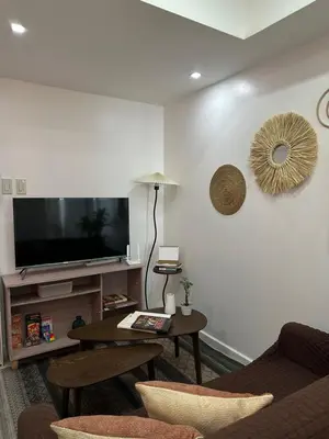 a living room with a tv and a table at CASA VANA in AZURE STAYCATION in Manila
